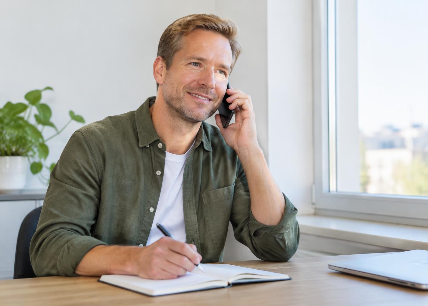 Recruitment consultant taking notes during a phone conversation